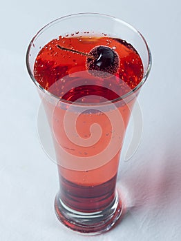 A glass of Cherry Juice close up with cherry fruit and Air Bubles