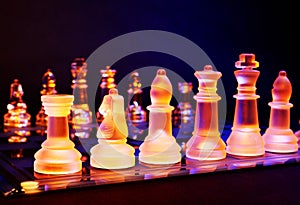 Glass chess on a chessboard lit by blue and orange light