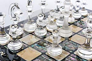 glass chess pieces is standing on board in white