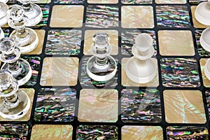 glass chess pieces is standing on board in white