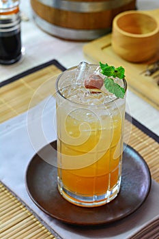 Glass of Chinese plum on round glass coaster, Napery