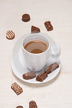 Glass of chocolate milk and variety chocolates on table