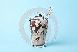 Glass chocolate milkshake on blue background. Summer drink