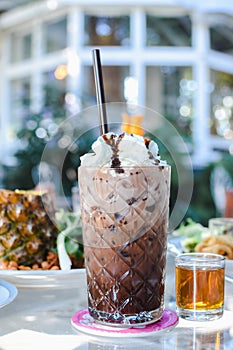 Glass of chocolate milkshake with whipped cream.