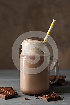 Glass chocolate milkshake on wooden table. Summer drink
