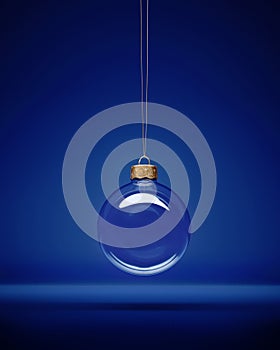 Glass christmas bauble hanging in front of luxury dark blue background photo