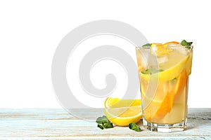 Glass of citrus refreshing drink on table against white background