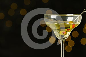 Glass of Classic Dry Martini with olives on blurred background