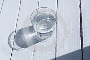 A glass with clean drinking water on a gray wood background