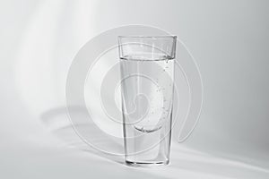 Glass of clean mineral sparkling water on white background