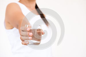 A glass of clean mineral water in woman`s hands.