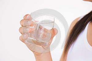 A glass of clean mineral water in woman`s hands