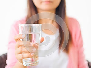 A glass of clean mineral water in woman`s hands.