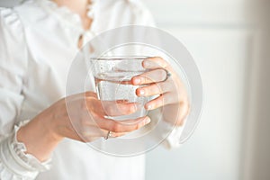Glass of clean mineral water in woman`s hands. Concept of environment protection, healthy drink