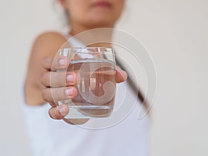 A glass of clean mineral water in woman`s hands. Concept of envi