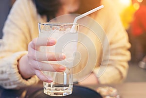 A glass of clean mineral water in woman`s hands. Concept of environment protection, healthy drink, glass of fresh Water