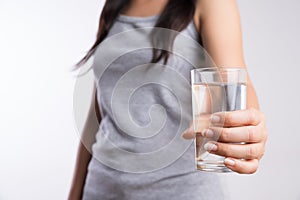 A glass of clean mineral water in woman`s hands. Concept of environment protection, healthy drink and healthcare