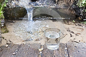 A glass of clean spring water outdoor. Source of clean natural water