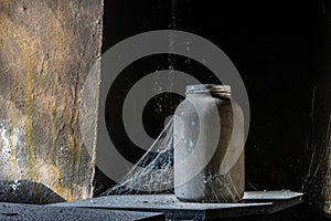 Glass and cobwebs in a dark room of a house