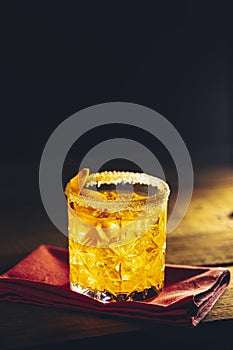 Glass of the cocktail negroni on a old wooden board. Drink with gin, campari martini rosso and orange, an italian cocktail, an