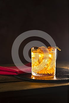 Glass of the cocktail negroni on a old wooden board. Drink with gin, campari martini rosso and orange, an italian cocktail, an