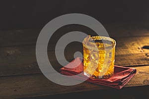 Glass of the cocktail negroni on a old wooden board. Drink with gin, campari martini rosso and orange, an italian cocktail, an