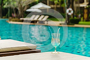 Glass of cocktail on sundeck at swimming pool