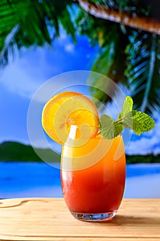 A glass of cocktail sunrise on a wooden board