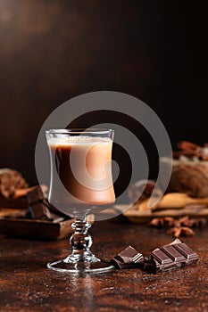 Glass of cocoa drink and pieces of dark chocolate