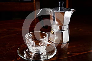 Glass coffee cup and vintage coffeepot on wooden table