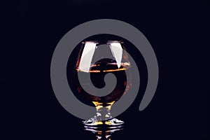 glass with cognac on a black background