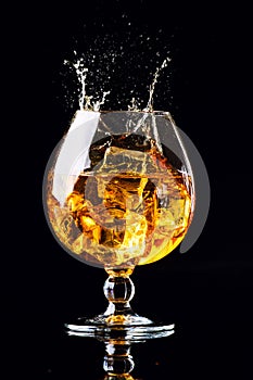 glass with cognac on a black background