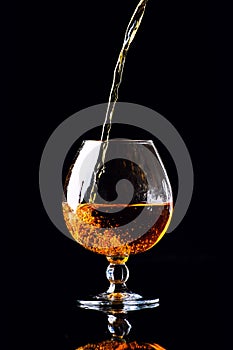 glass with cognac on a black background