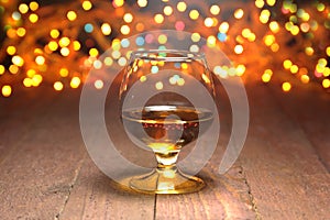 Glass of cognac, brandy or whiscy on mirror table. bottles in a bar on the background