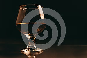 Glass of cognac on a dark background with