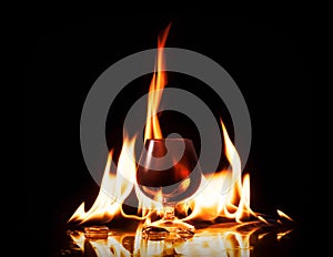 Glass of cognac in fire flame