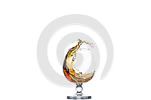 A glass of cognac with splashes from the ice cube isolated on white. alcohol splashes. whisky or cognac or another type of alcohol