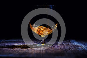 glass with cognac on a wooden background