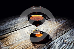 glass with cognac on a wooden background