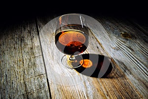 glass with cognac on a wooden background