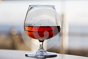 glass of cognac on a wooden table in the bar.