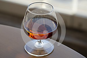 glass of cognac on a wooden table in the bar