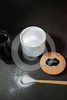 A glass of a coke drink and natural sweetener with s spoon, red background photo