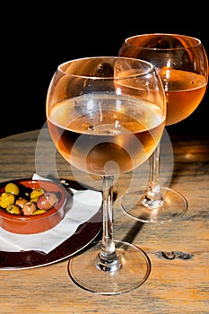 A glass of cold chilled rose wine served at a restaurant table. Water droplets are dripping