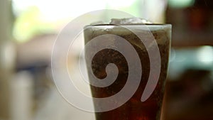 Glass of cold cola with ice. Soda or soft drink in 4K Resolution
