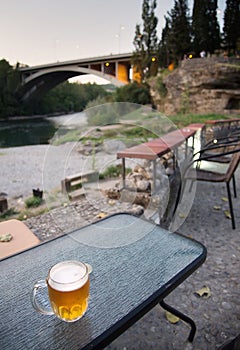 Glass of cold draught lager beer standing on a wall next to the Moraca river,Podgorica,Montenegro