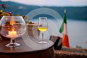 Glass of cold dry white wine served outdoor in cafe at night in Italy
