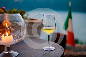 Glass of cold dry white wine served outdoor in cafe at night in Italy