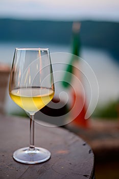 Glass of cold dry white wine served outdoor in cafe at night in Italy