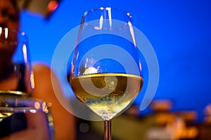 Glass of cold dry white wine served outdoor in cafe at night in Italy